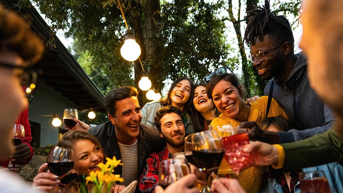 Group of people toasting with wine and beer   Happy friends having fun outdoor