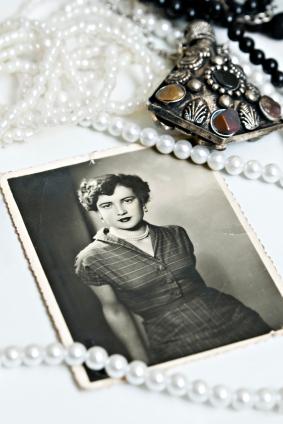 History of Mother's Day with an old photo of a woman surrounded by strings of pearls and other jewelry.
