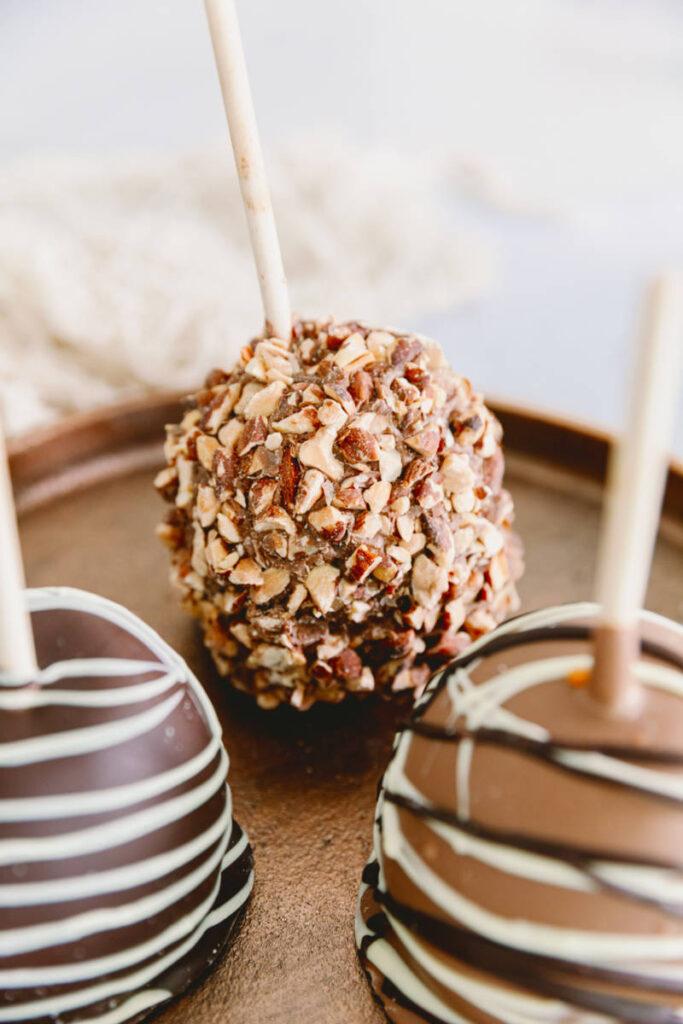 halloween snack board image   chocolate caramel covered apples on a wooden board