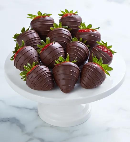 Dark chocolate covered strawberries on a platter.
