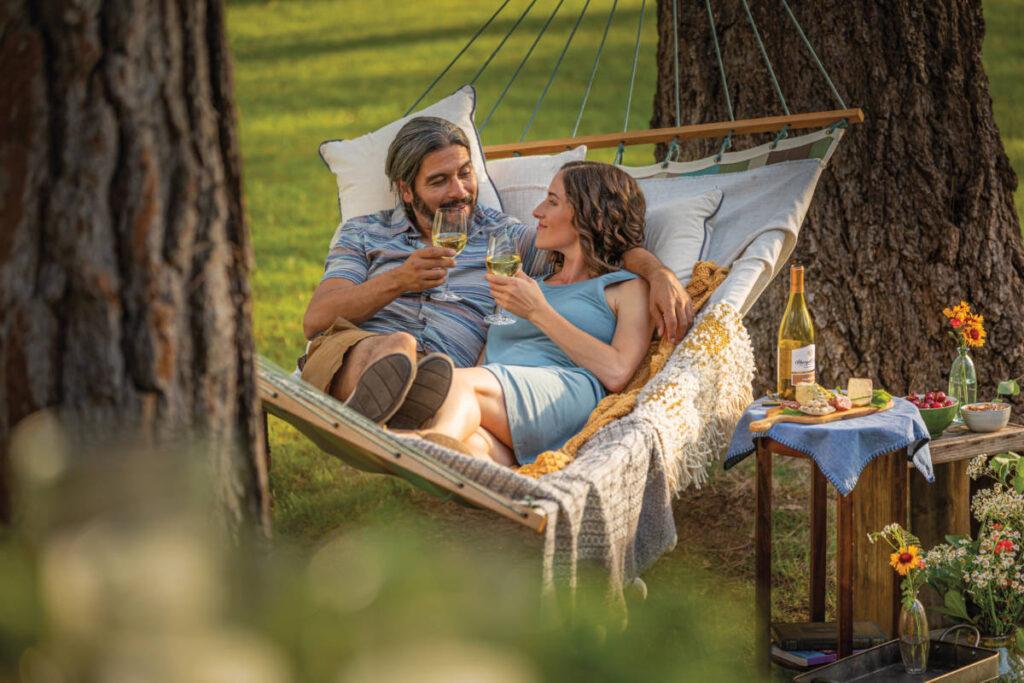 anniversary gifts by year image   couple drinking wine in hammock.