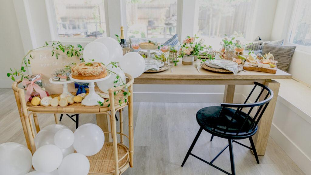host a baby shower image   table with flowers, balloons, and food.