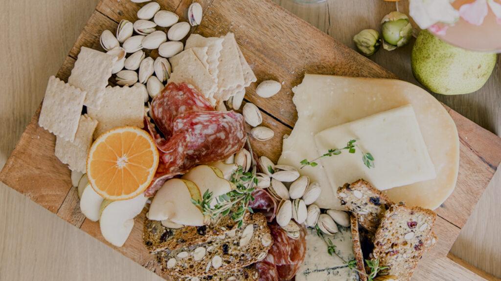 host a baby shower image   charcuterie board with crackers, fruit, cheese and meat.