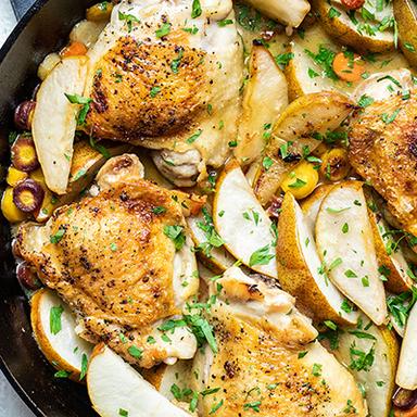 Pear braised chicken in a cast iron skillet.