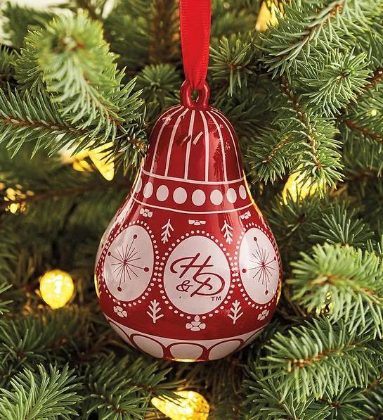 Gifts under $ with a Christmas ornament shaped like a pear hanging on a Christmas tree.