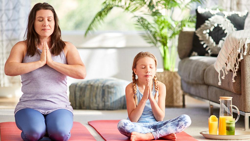 A photo of spring self care ideas with a woman and a young girl doing yoga next to a each other.