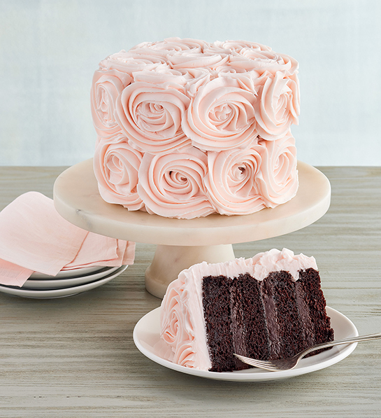 Pink frosted rose cake on a cake stand