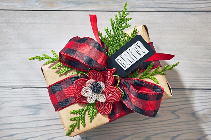 Christmas present wrapped with greenery and bow.