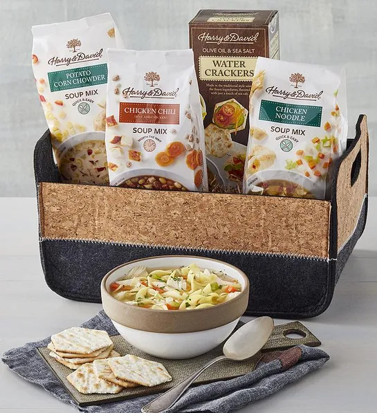 Best gift basket full of three bags of soup mixes and a box of crackers sitting next to a bowl of soup