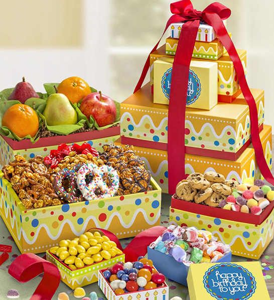 A photo of birthday gift ideas with a stack of birthday gifts next to several open boxes full of candy and fruit