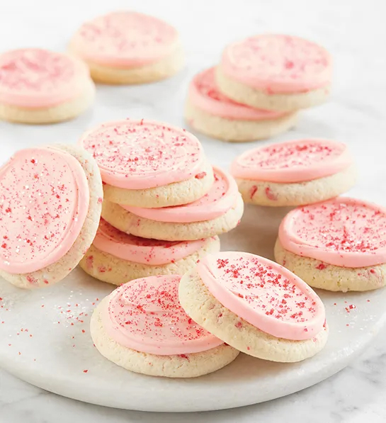 Gifts under  with a stack of pink frosted cookies