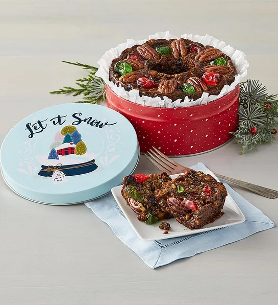 Gifts under  with a fruitcake in a Christmas themed tin