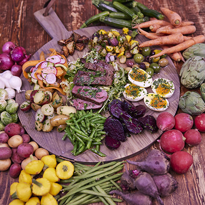 Steak salad on a board surrounded by fresh ingredients