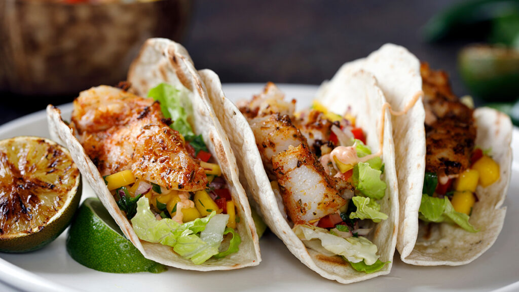 Wines for tailgating with a closeup of a plate of fish tacos.