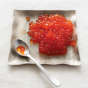 Caviar on a plate with a spoon next to it.