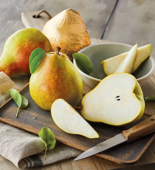 Gifting matrix with several whole and sliced pears on a wooden board