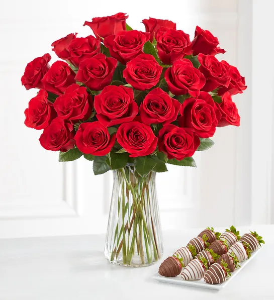 Gifting matrix with a bouquet of red roses next to a plate of chocolate covered strawberries