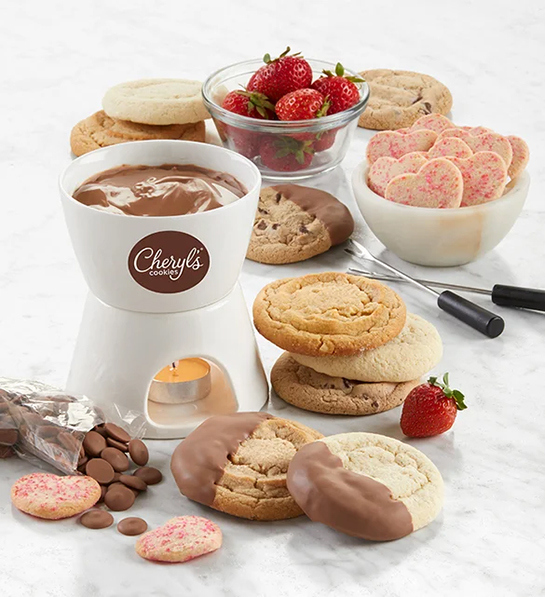 Valentines Day gifts for her with a chocolate fondue set surrounded by cookies and fruit