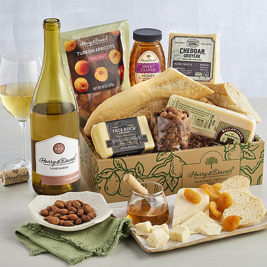 Bottle of chardonnay next to a box of cheese crackers nuts and other snacks