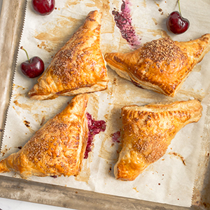 Cherry turnovers on a baking sheet