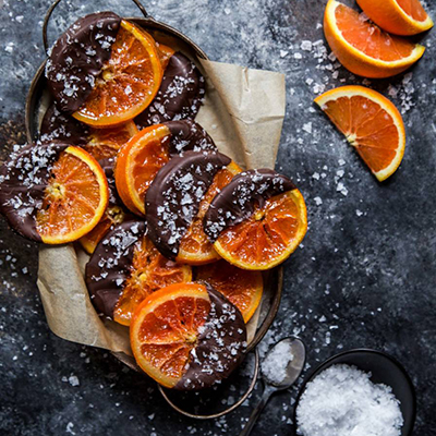 Sliced Cara Cara oranges dipped in chocolate and sprinkled with salt