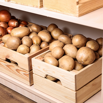 Crates with potatoes and onions on shelf Orderly storage