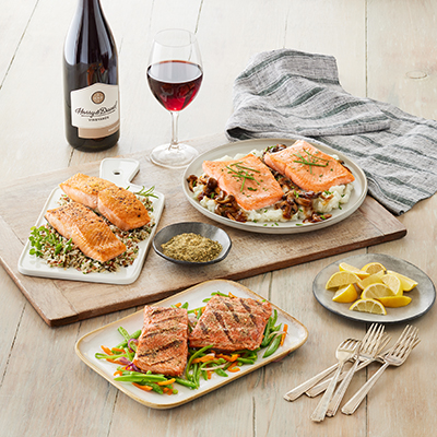 Winter wine pairings with plates of salmon and a bottle of pinot noir