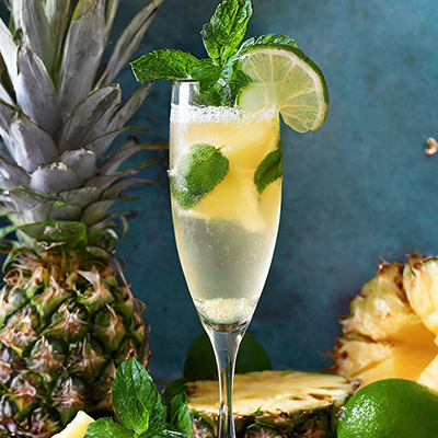 Pineapple recipes with a cocktail with pineapple and lime on a table