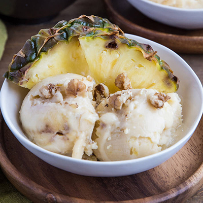 A bowl of pineapple nice cream with pineapple wedges