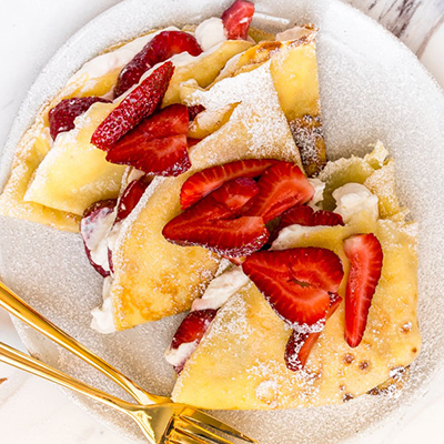 Strawberry recipes with a plate of crepes topped with strawberry