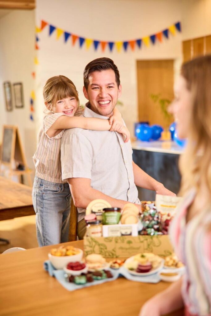 fathers day gift guide young daughter hugging dad from behind