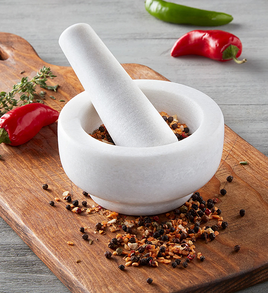 Gifts for the home cook with a white mortar and pestle full of spices