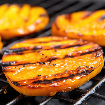 Slices of grilled mango on a grill