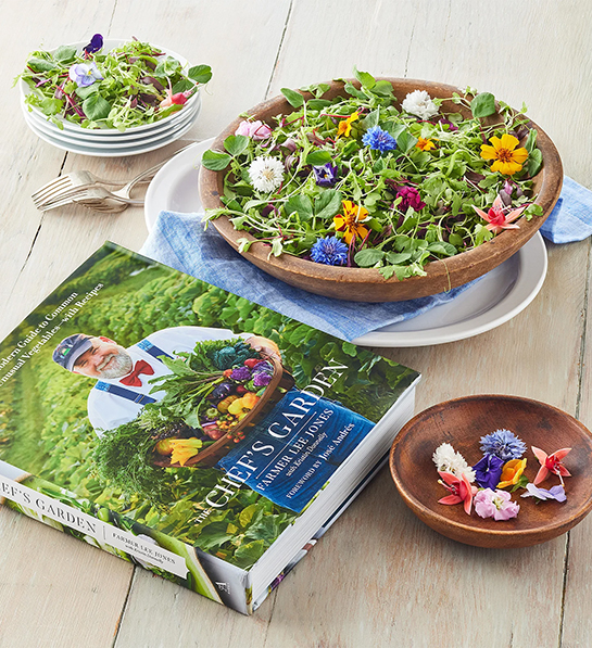 Thoughtful food gifts with a bowl of greens and flowers next to Chefs Garden cookbook